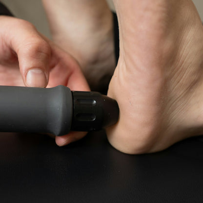 Massaggio del piede con la pistola massaggiante